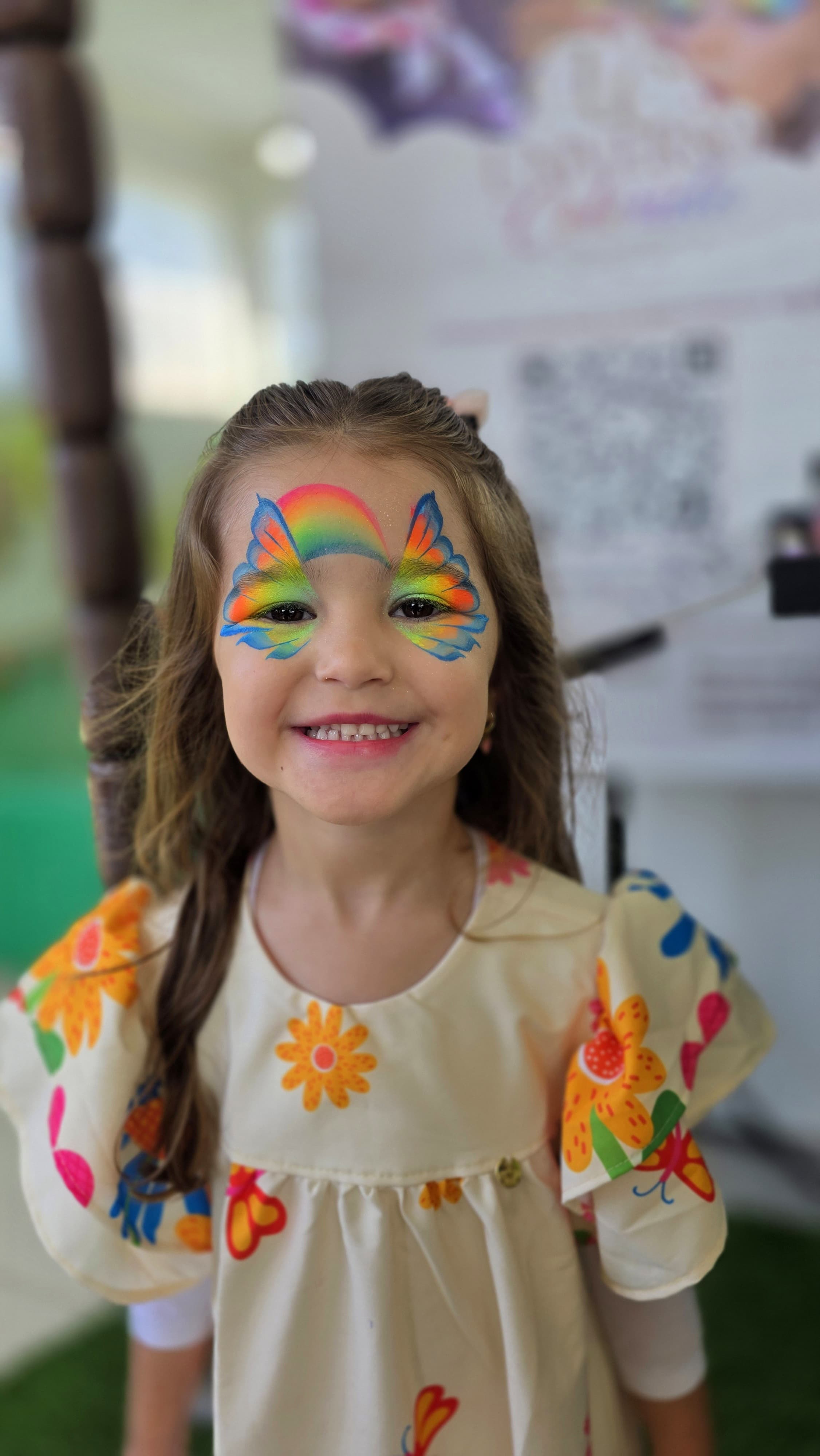 menina sorrindo com pintura artística facial de borboleta colorida